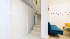 A modern interior with a staircase, a blue sofa, and a small table. - Via S. Liborio 79 - 6° Piano (Napoli)