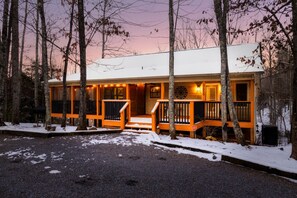 A cabin with a front porch, wooden railings, and a snow-covered ground. - Dollywood Smokies Hot Tub Gameroom Fire Pit Movie (Sevierville)