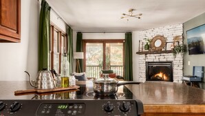 Una cocina con estufa Frigidaire, una chimenea y vistas al exterior a través de amplios ventanales.