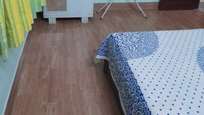 Ein Schlafzimmer mit Bett, Kleiderschrank, Spiegel und Fenster.