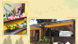 A kitchen with various food items and a dining area with a wooden table and chairs. - Pousada Dona Elena (Penha)