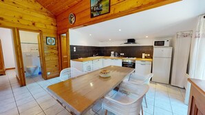 Un interior de madera con cocina, comedor y baño.