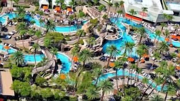 An aerial view of a resort with multiple swimming pools, palm trees, and lounge areas. -  Strip View/ MGM Signature Studio ★ No resort fees (Las Vegas)