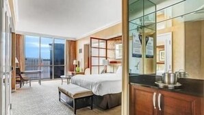 A hotel room with a bed, a small desk, a chair, a balcony, and a kitchenette. -  Strip View/ MGM Signature Studio ★ No resort fees (Las Vegas)
