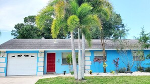 A single-story house with a blue exterior, a red door, and a garage.