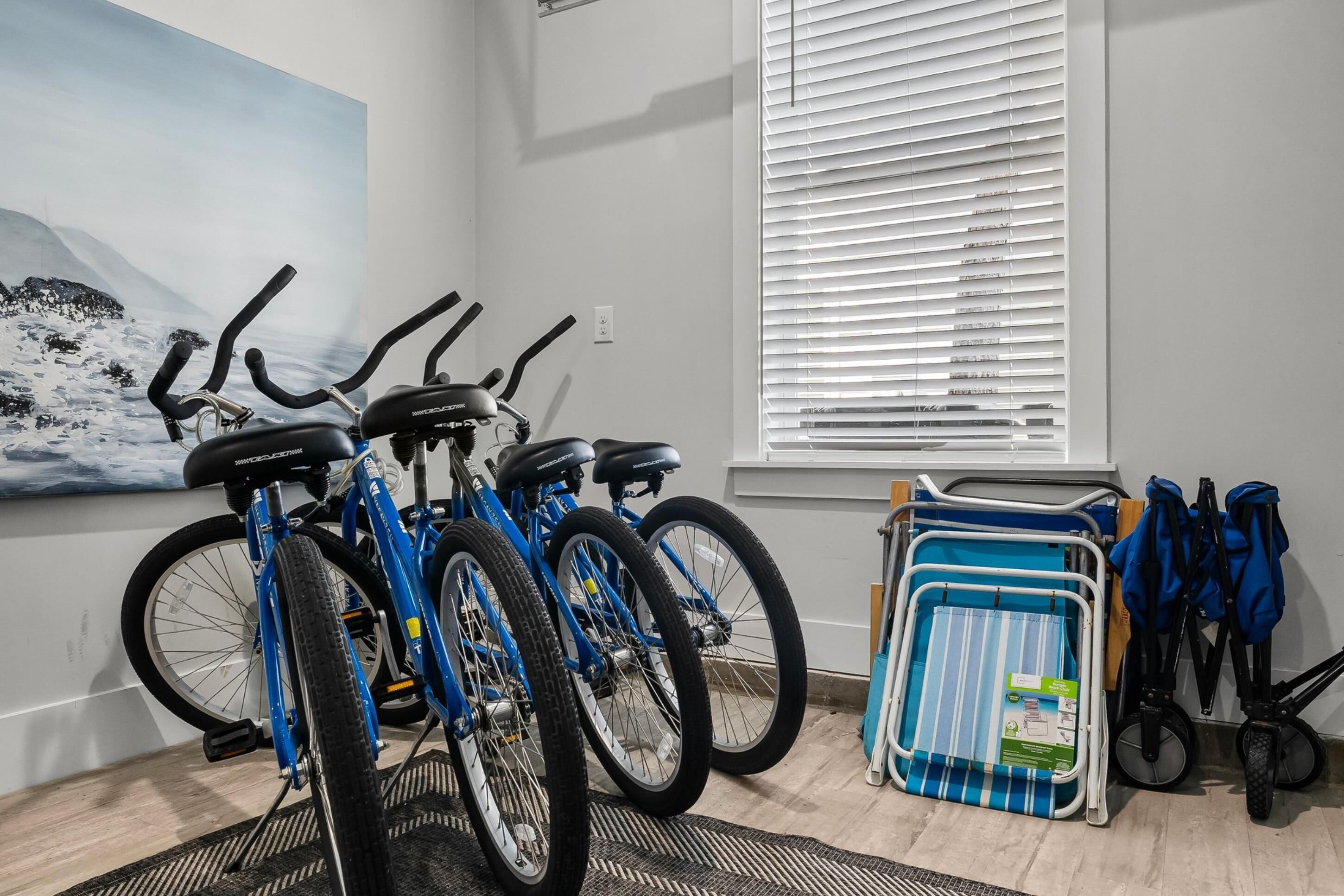 Una habitación con bicicletas, una silla plegable y una ventana con persianas.