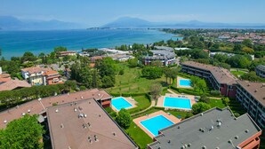 A high-rise hotel with rooftop pools, a view of the sea, and surrounding greenery. - DesenzanoLoft Dolce Vita (Desenzano del Garda)