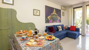 A dining area with a table set for breakfast, a sofa, and a painting of the Eiffel Tower. - DesenzanoLoft Dolce Vita (Desenzano del Garda)
