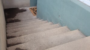 A concrete staircase leading to a door with a doormat that reads "Welcome Home." - Home Away Studio Basement Apartment w/Hideabed (Ogden)