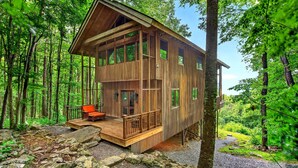 A wooden cabin with a deck, surrounded by a forest. - High Haven | Breathtaking Mountain Views! (Black Mountain)