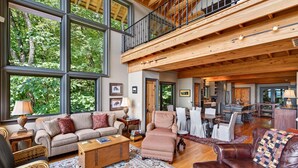 A spacious living area with large windows, a high ceiling, and a dining area. - High Haven | Breathtaking Mountain Views! (Black Mountain)