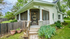 A single-story house with a front porch, a wooden fence, and potted plants. - Remodeled Rocheport Sunflower House - A Bungalow in Historic Rocheport (Rocheport)