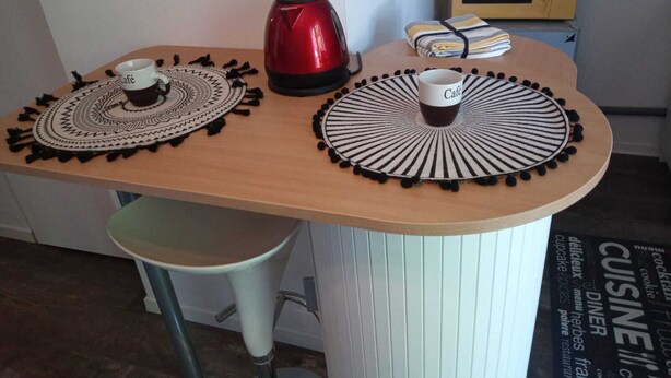 Een aanrecht met twee koffiekopjes, een rode waterkoker en een magnetron.