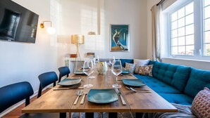 A dining area with a wooden table set for four, blue chairs, and a blue sofa with cushions.