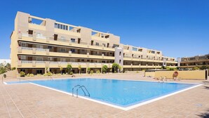 A multi-story hotel with a swimming pool. - Home2Book Bright Penthouse Médano, Terrace & Pool (El Medano)