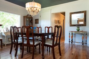 A dining room with a wooden table and chairs, a chandelier, a mirror, and a cabinet. - River House in historic Rockton, IL (Rockton)