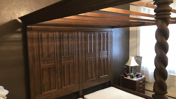 A bedroom with a wooden canopy bed, a large wardrobe, and a bedside table with a lamp. - Lodging Near Public Transportation (Acton)