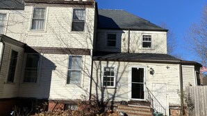 A two-story house with a gabled roof and a brick foundation. - Lodging Near Public Transportation (Acton)