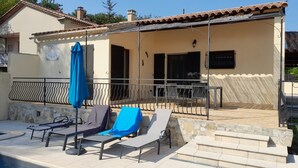 Ein Poolbereich mit Liegestühlen und einer überdachten Terrasse.