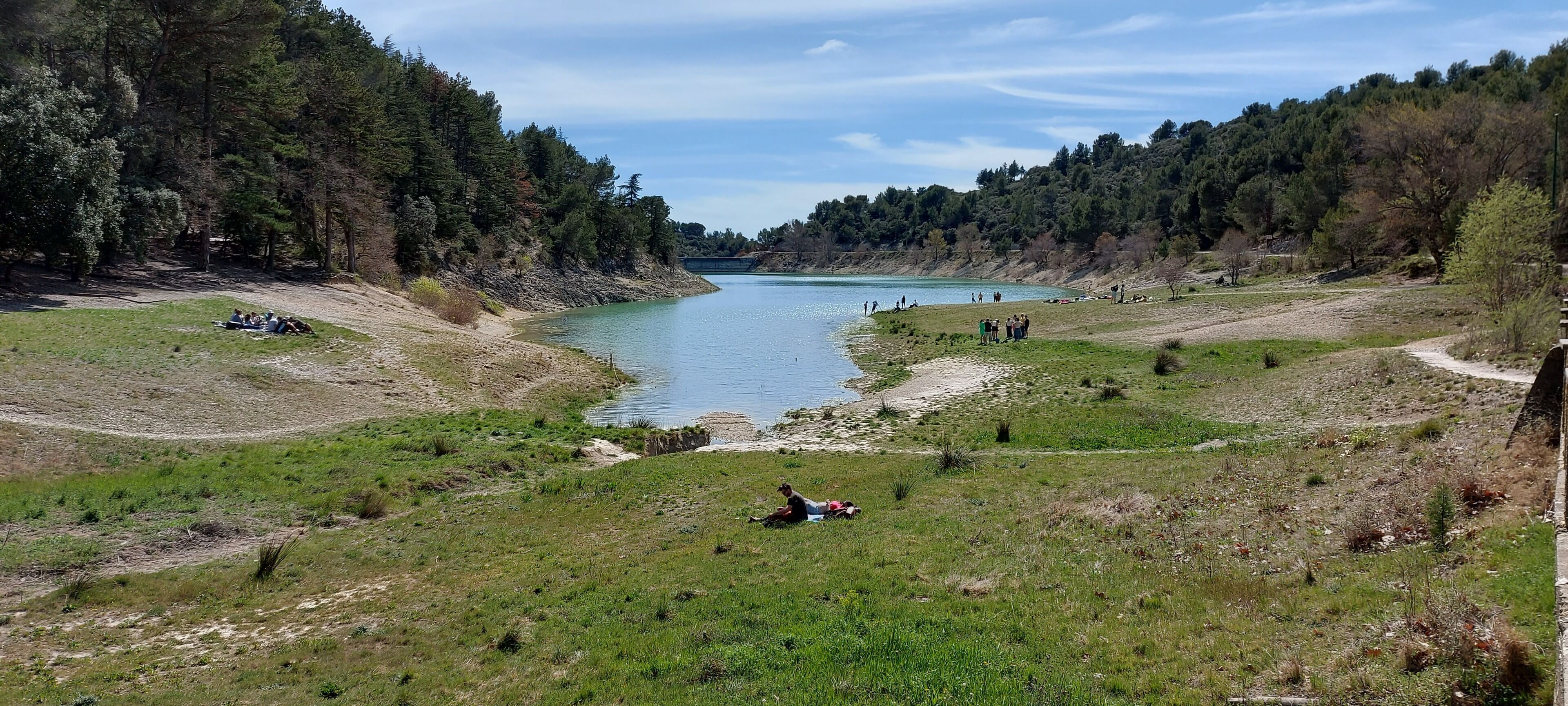 Un paysage naturel comprenant une rivière, des zones herbeuses et des arbres.