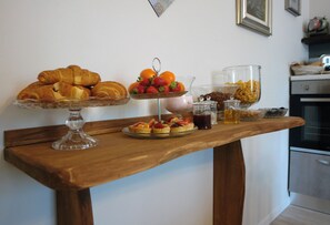 A breakfast table with pastries, fruit, and beverages. - B&B Erilla (Lonato del Garda)