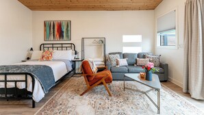 A bedroom with a bed, a chair, a sofa, a coffee table, and a window with curtains. - Close to downtown, with a llama, alpaca, and others animlas on the property (Thousand Oaks)