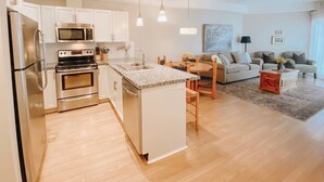 A modern apartment with a kitchen, dining area, and living room. - Okanagan four seasons paradise with shared pool and hot tub (Westbank)