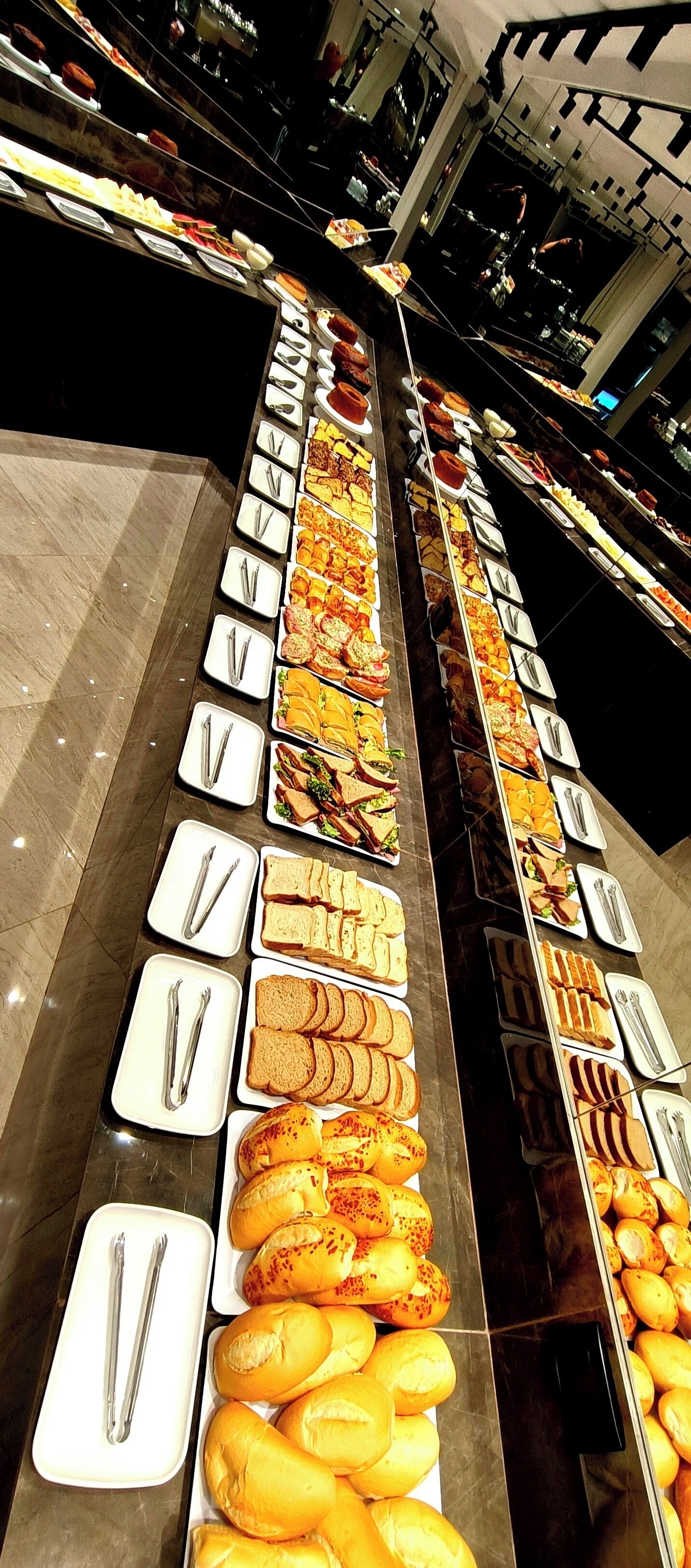 A buffet with various food items and utensils arranged on trays.