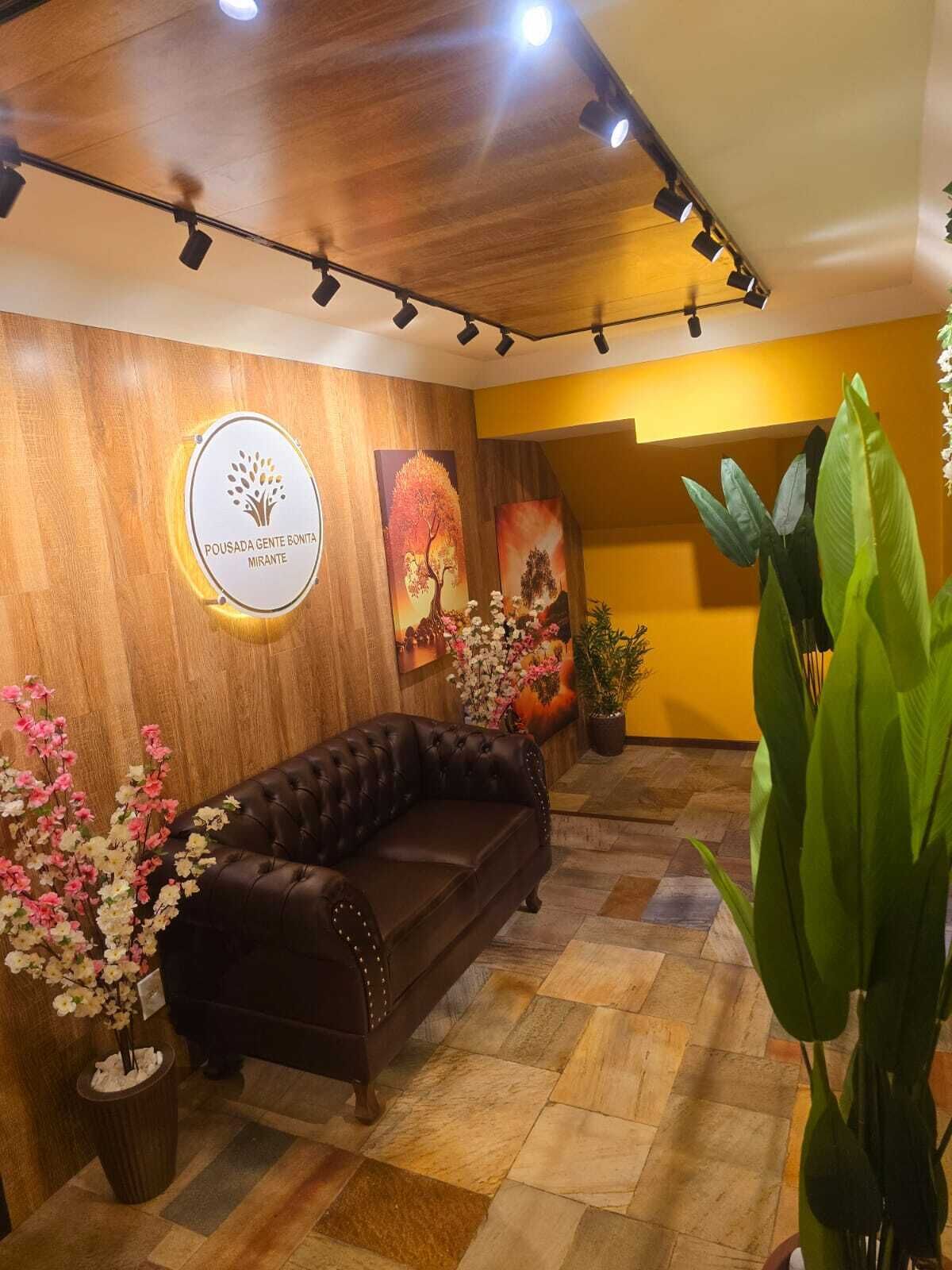 A reception area with a leather sofa, wooden wall panels, and a logo on the wall.
