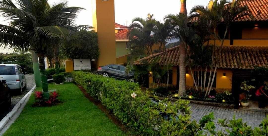 Un patio con sendero adoquinado, palmeras y un edificio de techo con tejas.