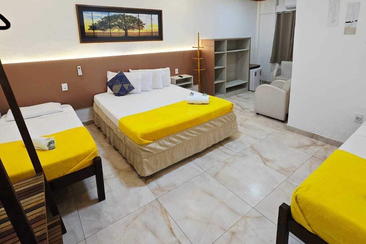 A hotel room with two beds, a bathroom, and a small sitting area.