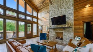 Una televisión de pantalla plana, una chimenea, videojuegos, un futbolín