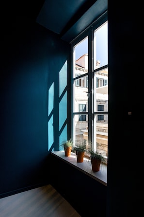 Enjoy the urban view from this room with a large window and potted plants.
