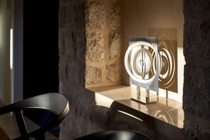 Relax in a stylish seating area with a unique light fixture and stone accent wall.