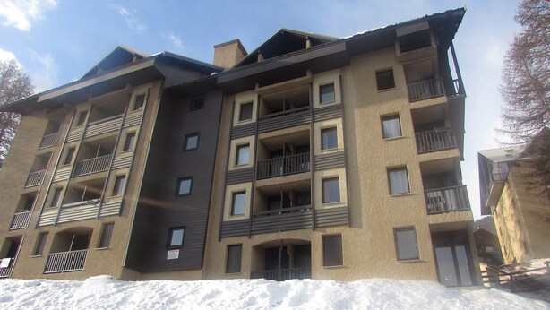 Un edificio a più piani con balconi e finestre, immerso nella neve.