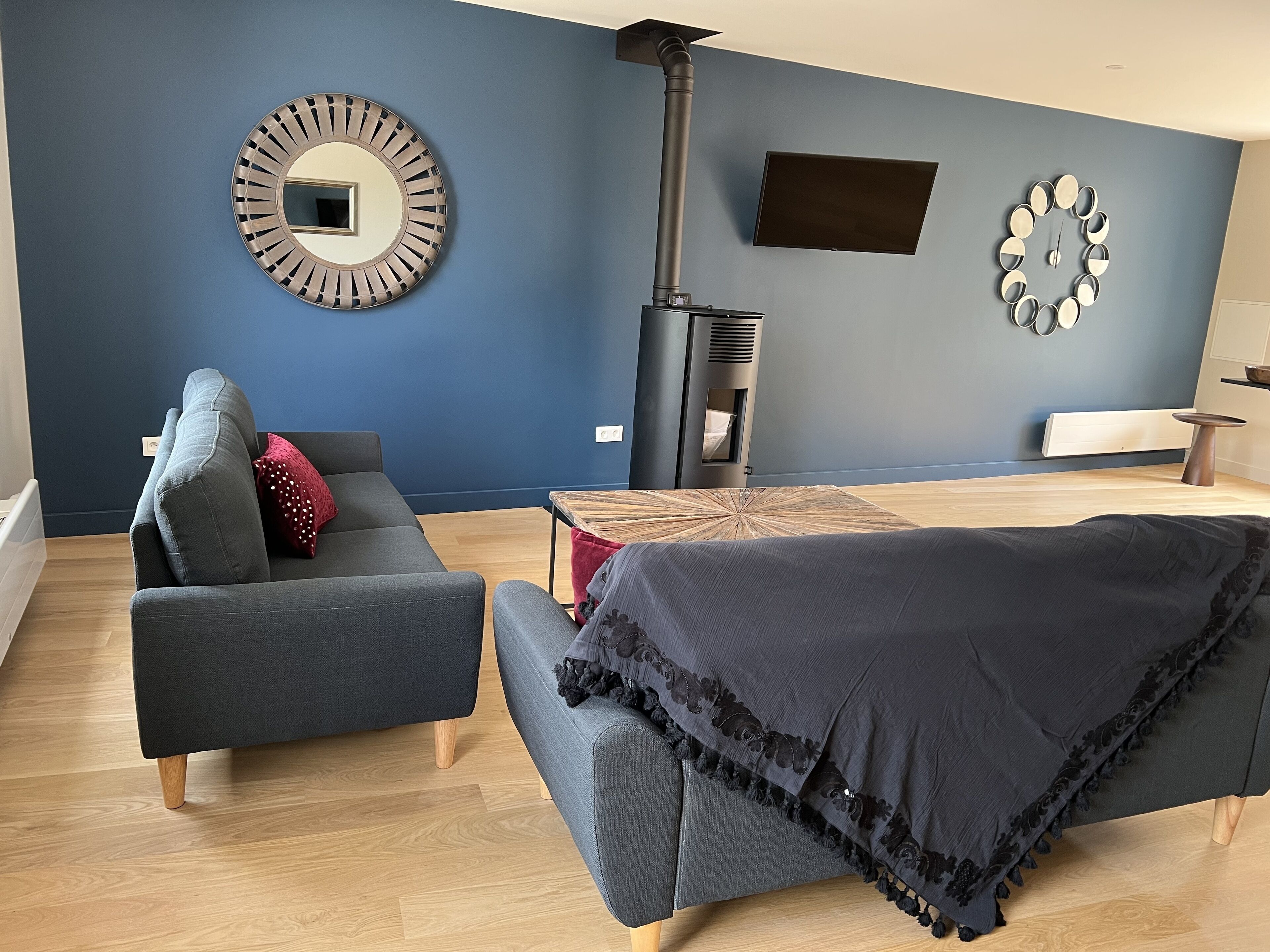 Un salon moderne comprenant un canapé, une table basse, une cheminée et des œuvres d’art décoratives murales.