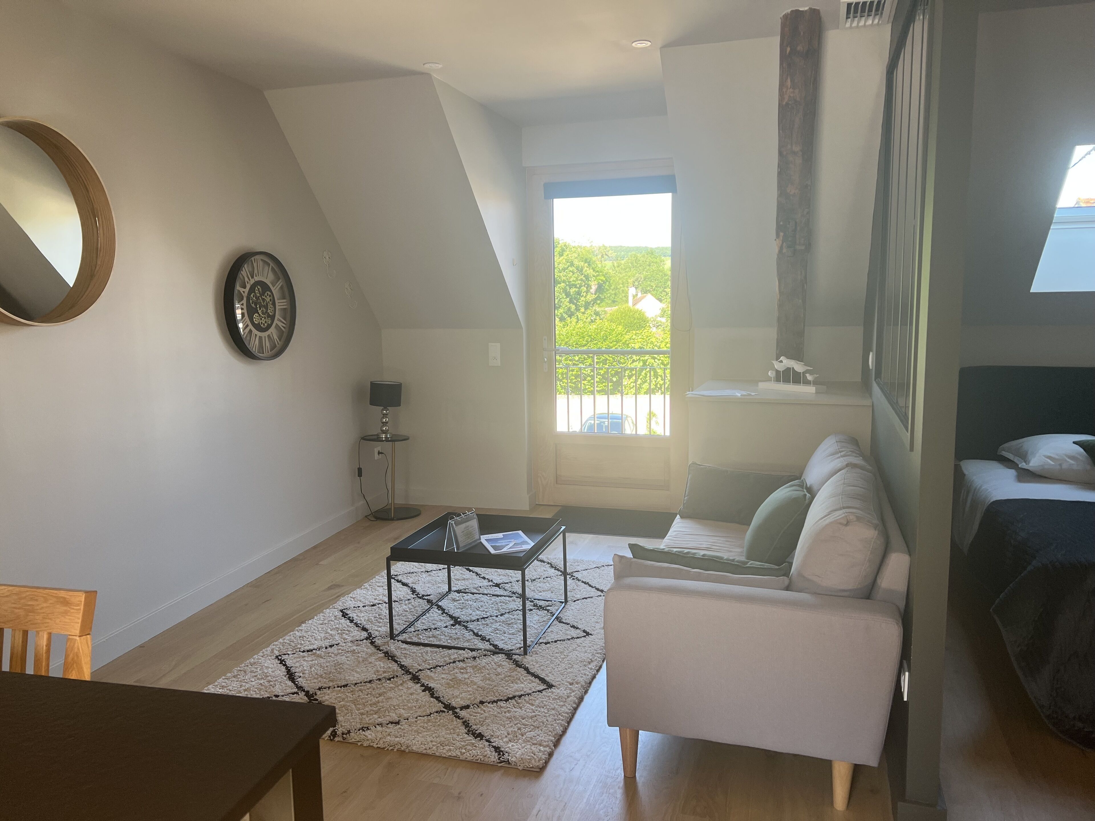 A modern living room with a sofa, a coffee table, and a dining area.