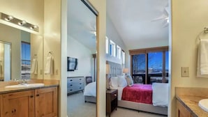A bedroom with a bed, bedside table, and a window. - skiNewpark33: Walkable w/View, Deck, Hot Tub, Garage (Park City)