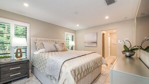 A bedroom with a bed, bedside table, lamp, and a potted plant. - Newly Renovated, Beach Close, Pet Friendly, Modern Luxury Retreat (Naples)