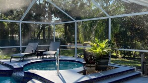 A covered outdoor swimming pool with a tiled edge, lounge chairs, and potted plants. - Newly Renovated, Beach Close, Pet Friendly, Modern Luxury Retreat (Naples)