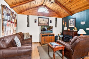 Ein gemütliches Wohnzimmer mit Ledersofas, einer Holzeinrichtungsanlage und einem Kamin.