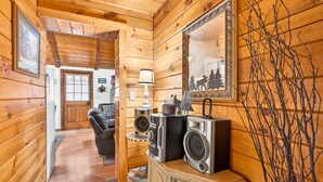 Un intérieur en bois comprenant un canapé, une lampe, un miroir et un système de haut-parleurs.