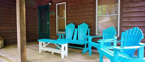 A wooden porch with a table and four chairs.