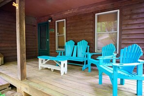 Une véranda en bois avec une table et quatre chaises.