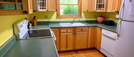 A kitchen with wooden cabinets, a sink, a stove, and a refrigerator.