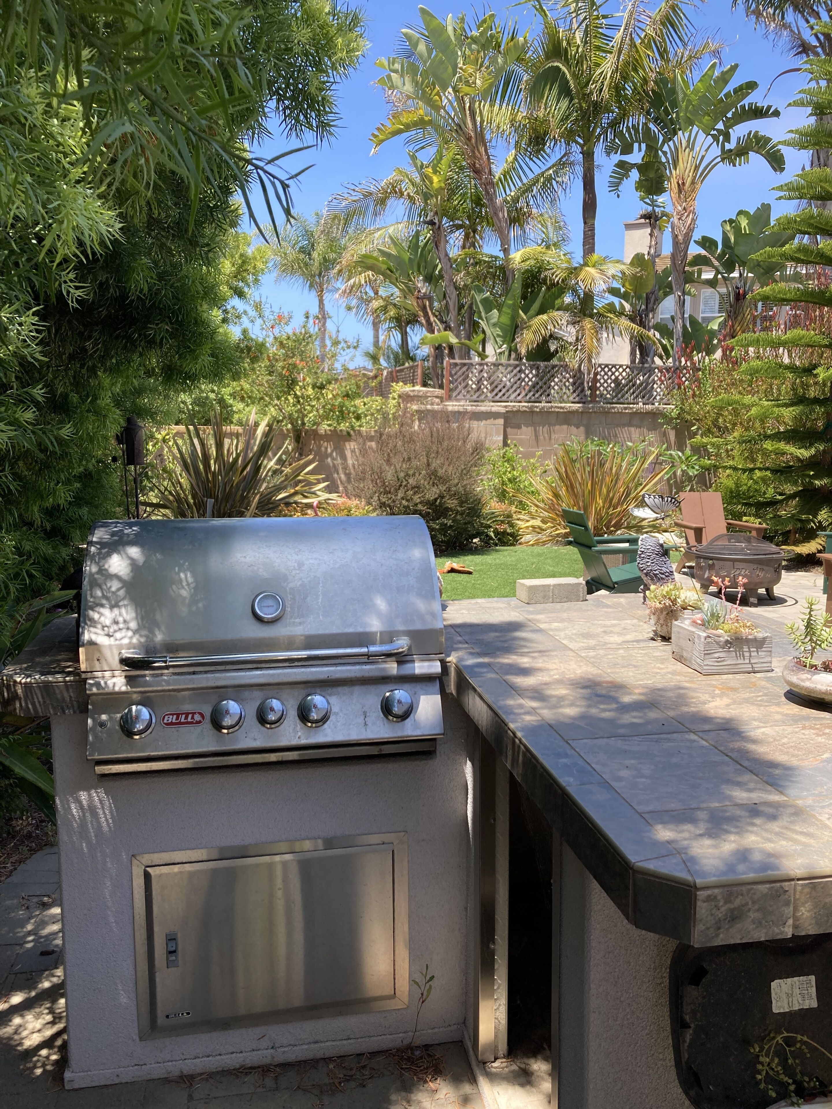 Un barbecue en acier inoxydable doté de quatre brûleurs, d’une ouverture de ventilation latérale et d’un panneau de commande.