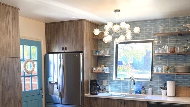 A modern kitchen with a central island, stainless steel appliances, and a view of the outdoors. - Updated Mid-Century beach house --10 minute walk to the beach (Carlsbad)