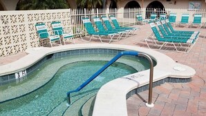 A swimming pool with a 3 ft depth marker, surrounded by lounge chairs and a white fence. - Newly Renovated 1 Bed/1.5 Bath Mobile Home Near Ft. Myers Beach, Florida (Fort Myers)