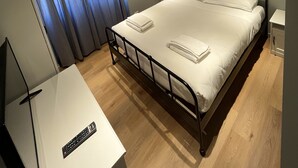 A neatly arranged bedroom with a bed, bedside table, and a TV stand. - Carpegna House. Lovely apartment: Rome (Roma)