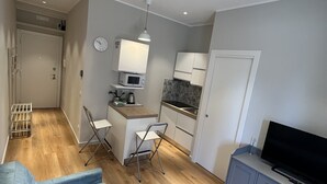A compact living space with a kitchenette, a dining area, and a seating area with a sofa and a TV. - Carpegna House. Lovely apartment: Rome (Roma)